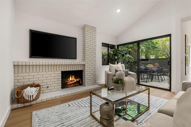 living area featuring a brick fireplace, wood finished floors, baseboards, high vaulted ceiling, and recessed lighting