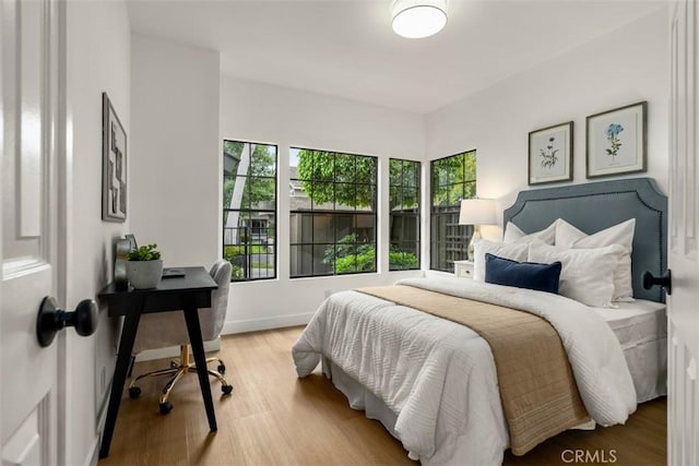 bedroom featuring baseboards and light wood finished floors