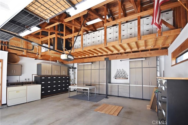 garage featuring washing machine and clothes dryer, water heater, and a garage door opener