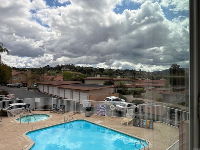 community pool featuring fence and a patio area