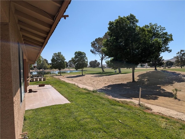 view of yard with a water view and a patio area