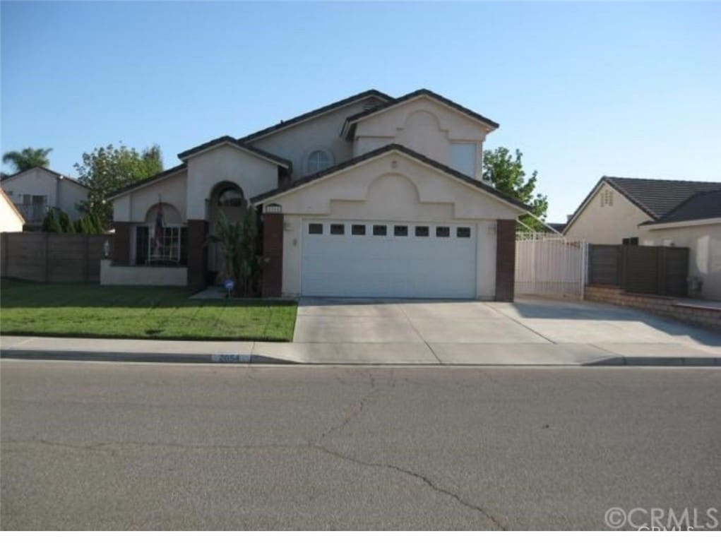 view of front of home featuring a garage, stucco siding, fence, and concrete driveway