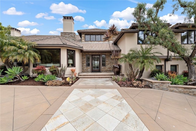27561 Silver Creek Dr, San Juan Capistrano, CA 92675 - back of property with a chimney, stucco siding, a tiled roof, and stone siding