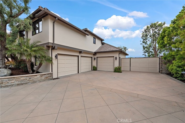 27561 Silver Creek Dr, San Juan Capistrano, CA 92675 - view of front of property with a garage, stucco siding, and concrete driveway