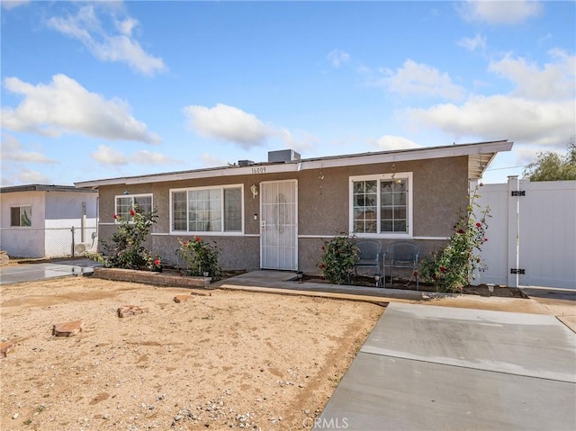 ranch-style house with fence, a gate, and stucco siding
