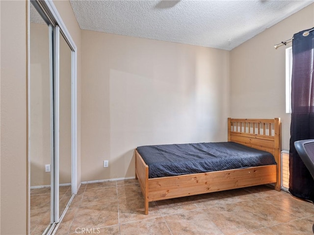 bedroom with a textured ceiling and light tile patterned floors