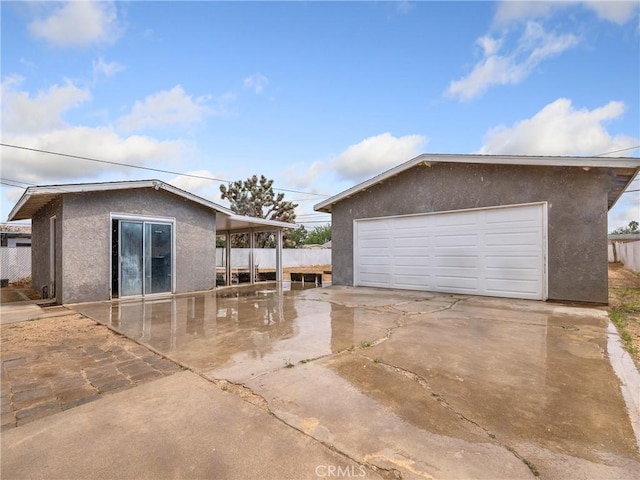 view of property exterior featuring a detached garage and stucco siding