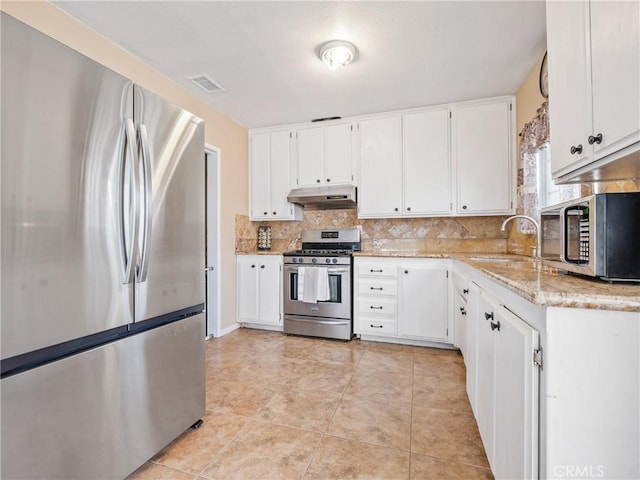 kitchen with a sink, stainless steel appliances, under cabinet range hood, visible vents, and backsplash