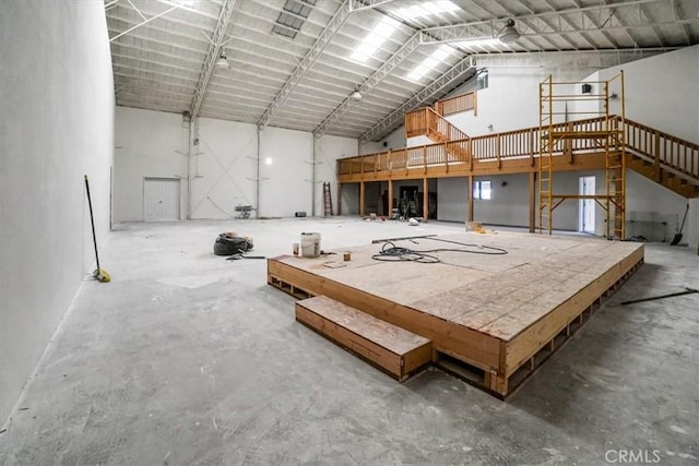 miscellaneous room with unfinished concrete floors and high vaulted ceiling