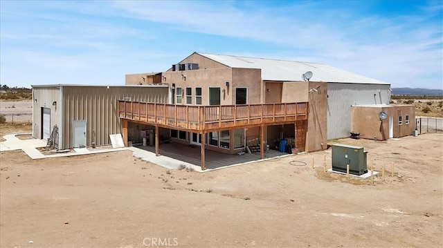 rear view of house featuring a wooden deck