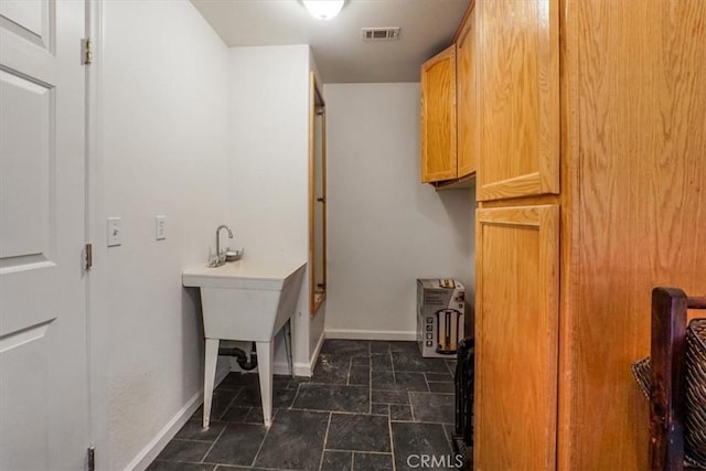 laundry room with baseboards and visible vents