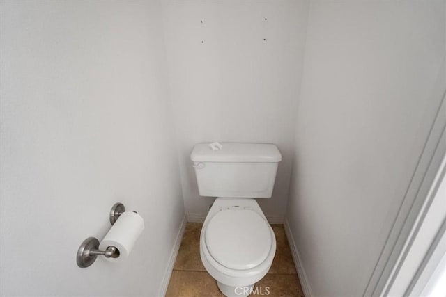 bathroom featuring toilet, tile patterned flooring, and baseboards