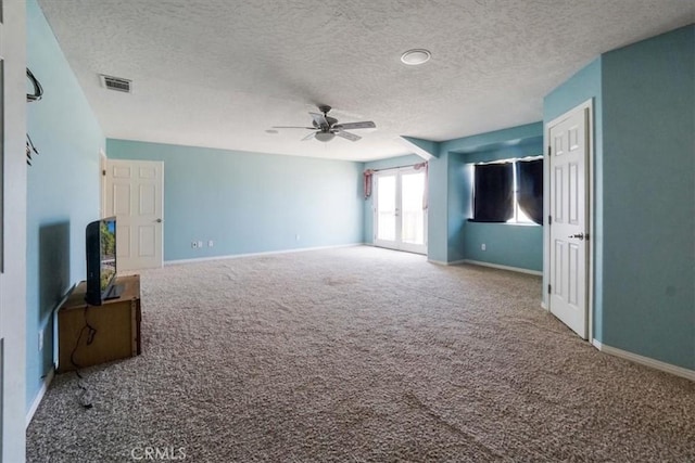 unfurnished living room featuring carpet, visible vents, a ceiling fan, and baseboards
