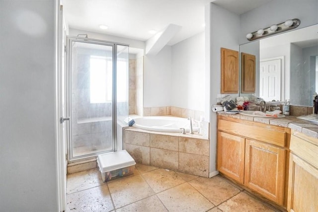 bathroom with vanity, a bath, and a stall shower
