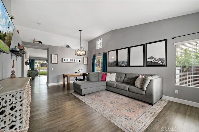 living room with wood finished floors, a healthy amount of sunlight, a notable chandelier, and baseboards