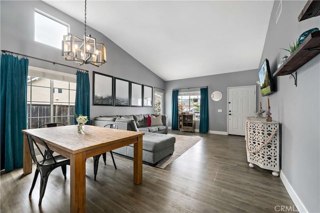 dining room with an inviting chandelier, high vaulted ceiling, wood finished floors, and baseboards