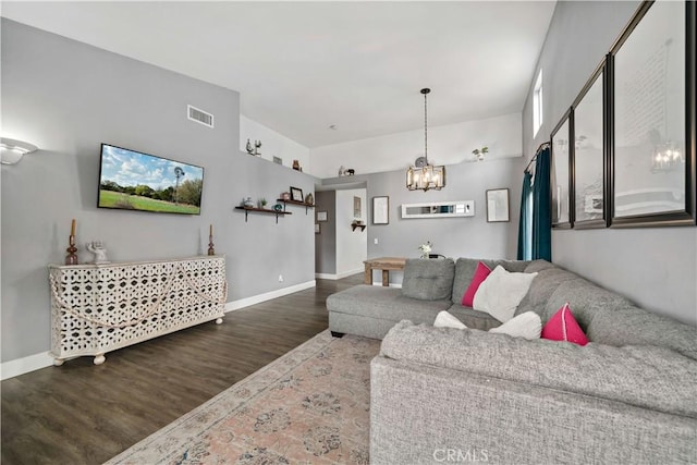 living room featuring visible vents, a chandelier, wood finished floors, and baseboards