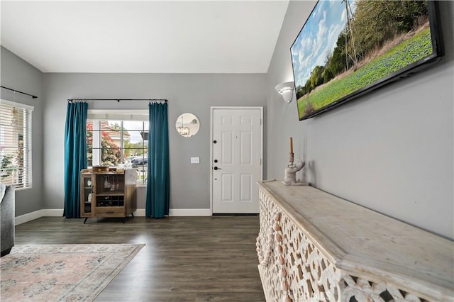 entryway featuring baseboards, a healthy amount of sunlight, lofted ceiling, and dark wood-type flooring