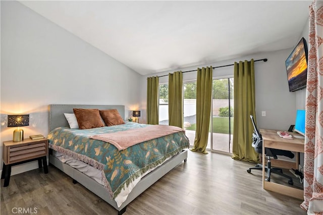 bedroom featuring lofted ceiling, access to outside, and wood finished floors