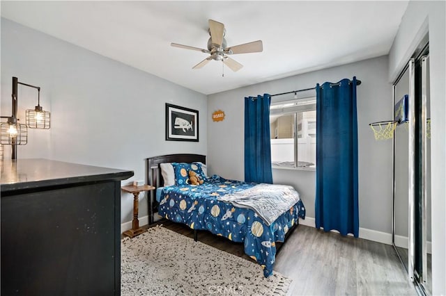 bedroom featuring baseboards, wood finished floors, and ceiling fan