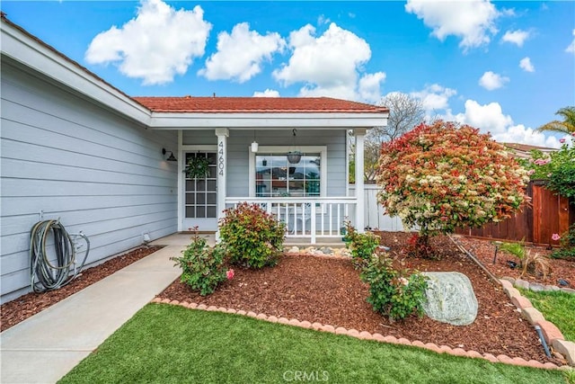 entrance to property featuring fence and a porch