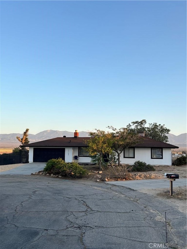 ranch-style home with a mountain view, driveway, and a garage