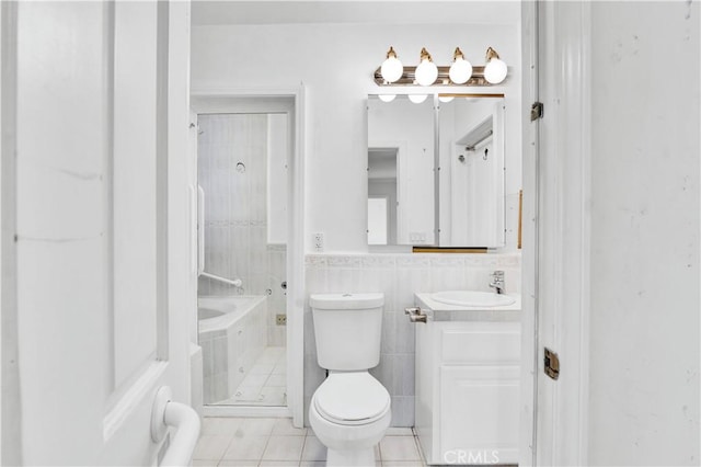 bathroom with walk in shower, toilet, tile walls, tile patterned floors, and vanity