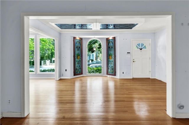 foyer with ornamental molding, wood finished floors, and baseboards