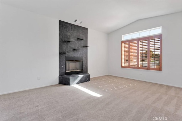 unfurnished living room featuring lofted ceiling, visible vents, a fireplace, and carpet floors