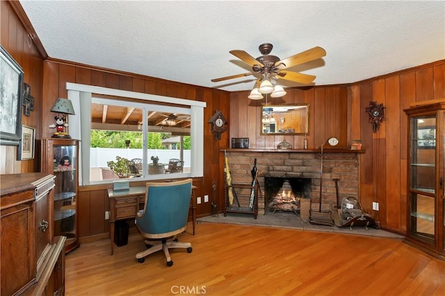 370 W 13th St, Upland, CA 91786 - office space with light wood-style floors, a stone fireplace, wood walls, ceiling fan, and a textured ceiling