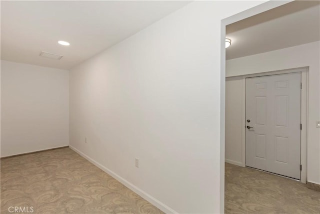 spare room featuring baseboards, recessed lighting, and light carpet