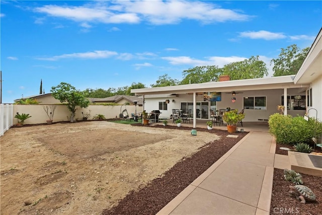 rear view of property with a patio area, ceiling fan, a fenced backyard, a chimney, and stucco siding