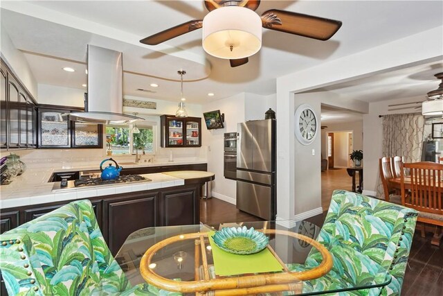 370 W 13th St, Upland, CA 91786 - kitchen featuring tile countertops, appliances with stainless steel finishes, island range hood, glass insert cabinets, and dark brown cabinets