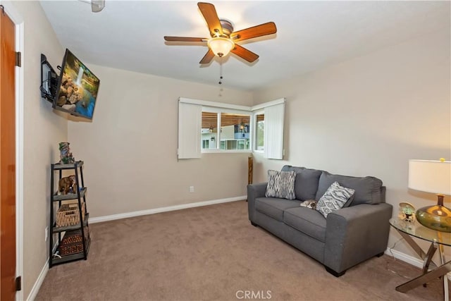 carpeted living area with ceiling fan and baseboards
