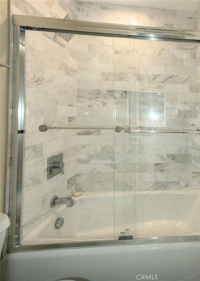 full bathroom featuring bath / shower combo with glass door