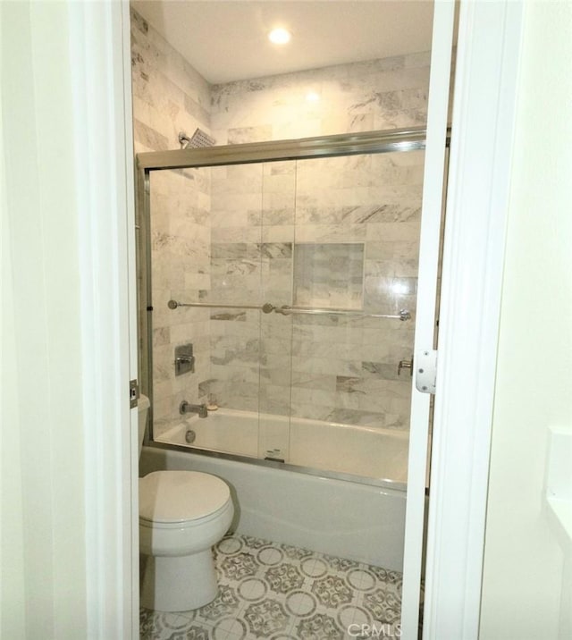bathroom featuring shower / bath combination with glass door, toilet, and tile patterned flooring