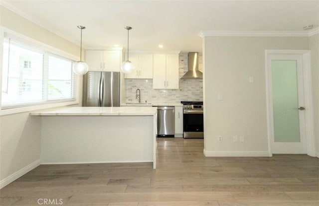 kitchen with a sink, tasteful backsplash, wall chimney exhaust hood, ornamental molding, and appliances with stainless steel finishes