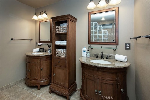 bathroom featuring baseboards, two vanities, tile patterned flooring, and a sink