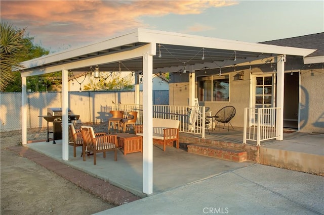 patio terrace at dusk with a grill and fence