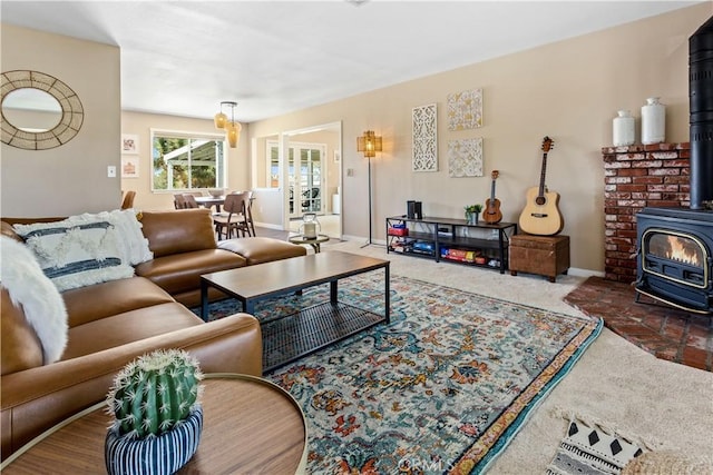 carpeted living area featuring a wood stove and baseboards