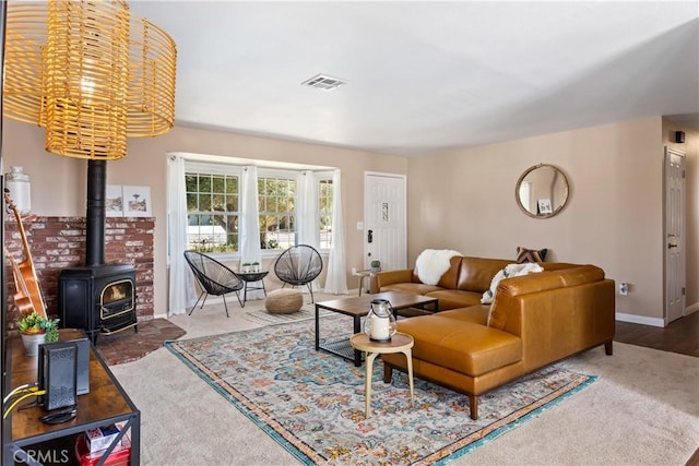 living room with visible vents, a wood stove, and baseboards