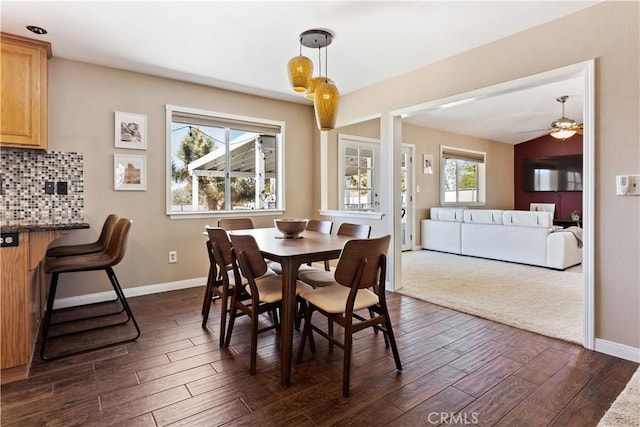 dining room featuring a ceiling fan, baseboards, and dark wood-type flooring