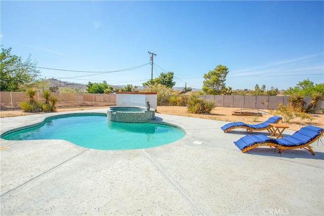 view of swimming pool featuring a pool with connected hot tub, a patio, and a fenced backyard