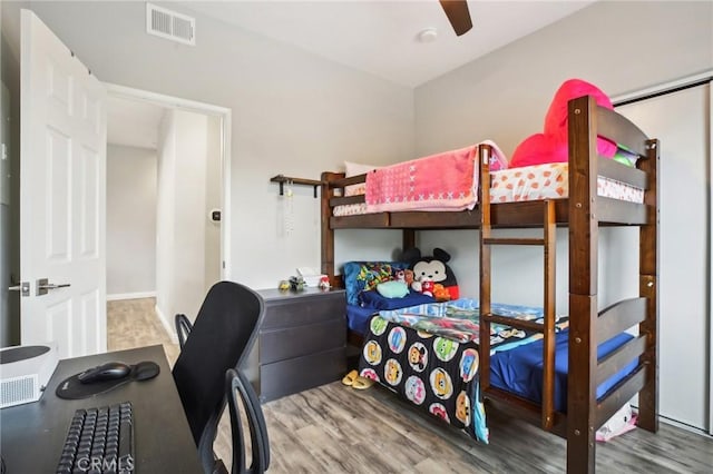 bedroom with visible vents, wood finished floors, and a ceiling fan