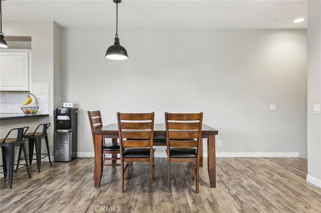 dining area featuring recessed lighting, wood finished floors, and baseboards