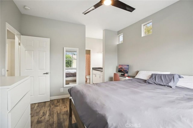 bedroom featuring baseboards, ensuite bathroom, multiple windows, and dark wood-type flooring
