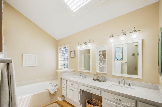 full bath featuring a garden tub, double vanity, a sink, and lofted ceiling