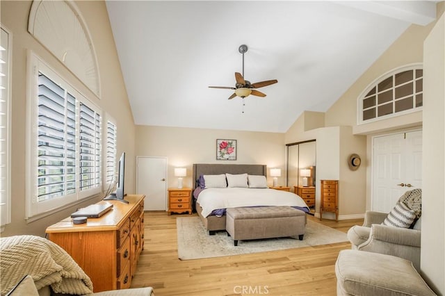 bedroom featuring high vaulted ceiling, beamed ceiling, a ceiling fan, and light wood-style floors