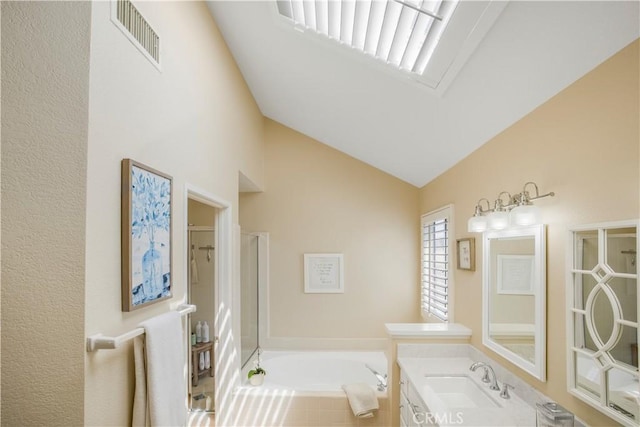 bathroom with walk in shower, vanity, visible vents, a garden tub, and lofted ceiling