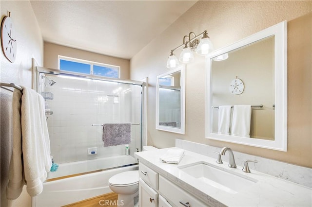 bathroom with bath / shower combo with glass door, vanity, and toilet